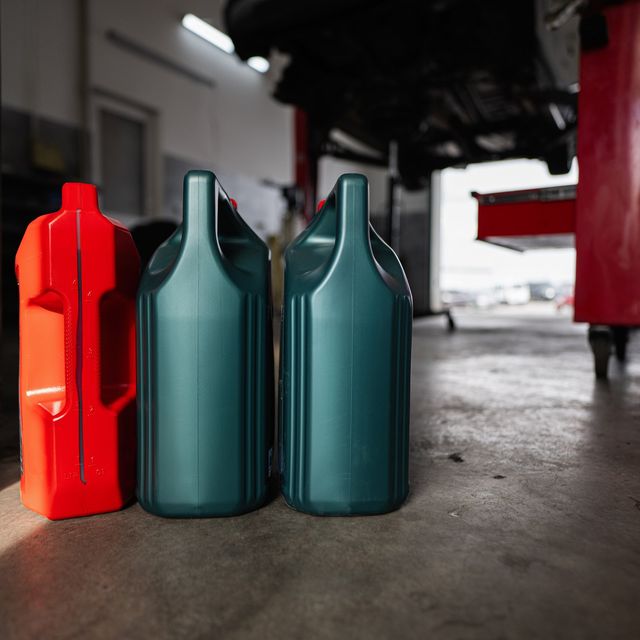 Photo: Red and green motor oil containers in an auto repair garage