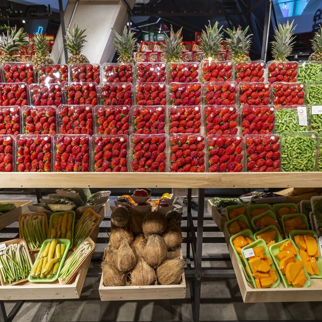 Photo: Rows of fresh red and green produce in cartons on grocery store shelves