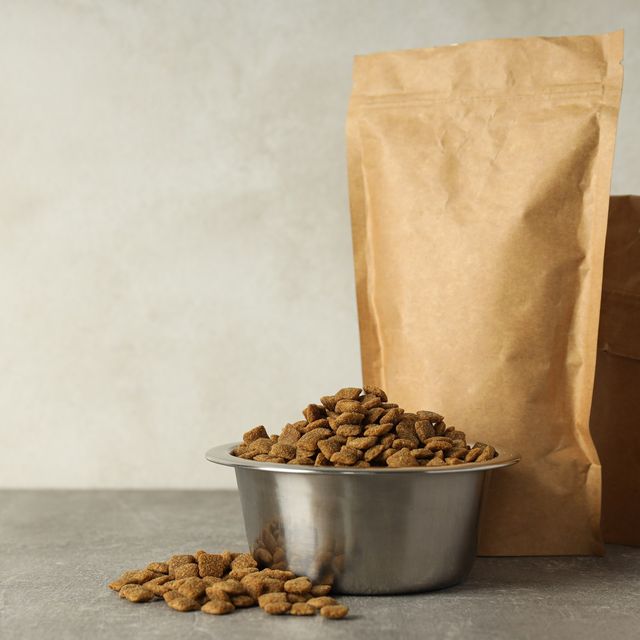 Photo: Paper bag of pet food and a steel bowl of kibble on a counter